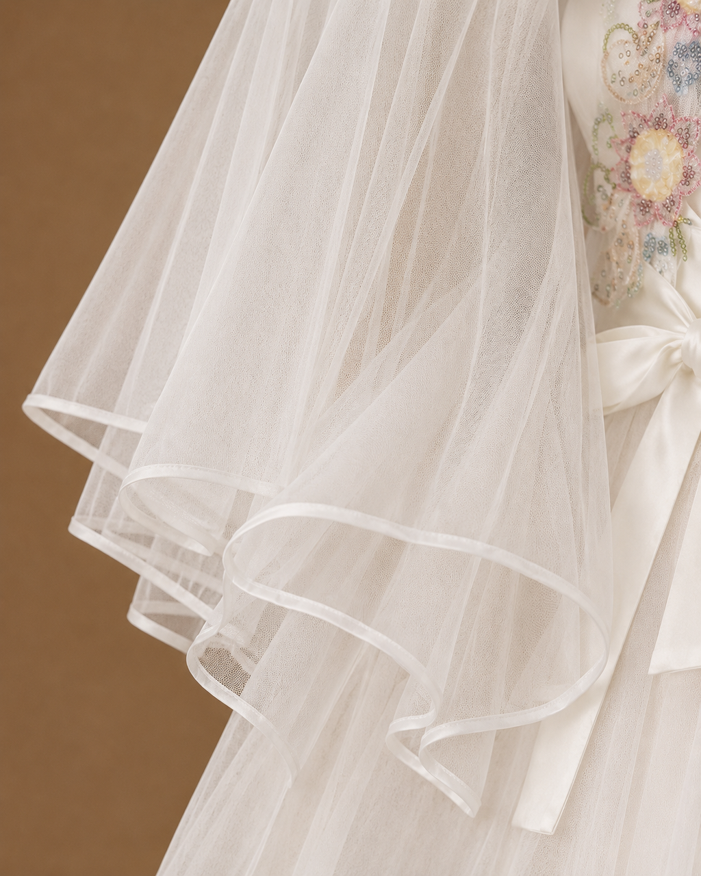 Fabric detail of the SABRINE ivory bridal set with flowing sheer tulle, satin trim and pastel floral embroidery